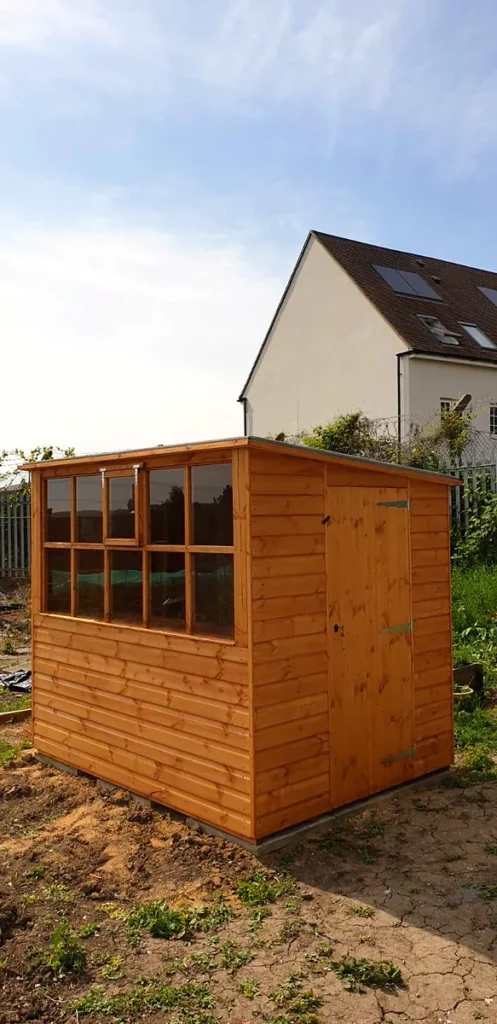 Garden potting shed with a timber door and glazed side